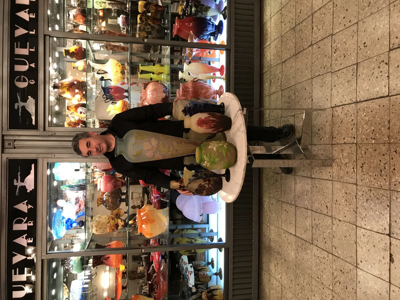 Vase antigüo firmado Gallé en exhibición con otros objetos decorativos