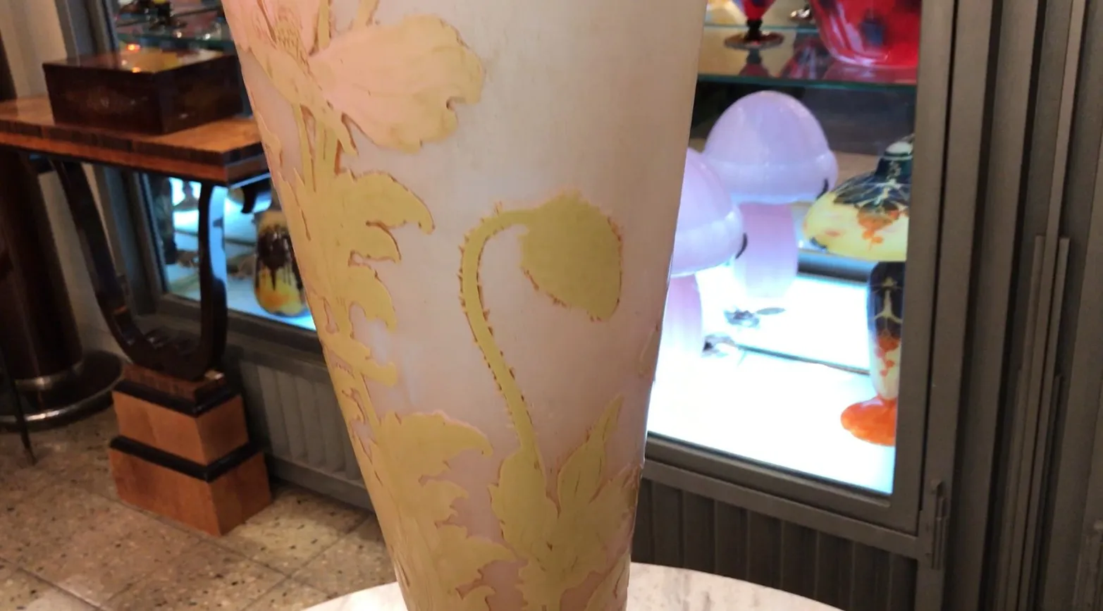 An elegant signed glass Gallé with floral design, displayed in an antique setting