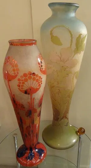 deux vases décoratifs, l'un avec des fleurs rouges et l'autre avec un design vert