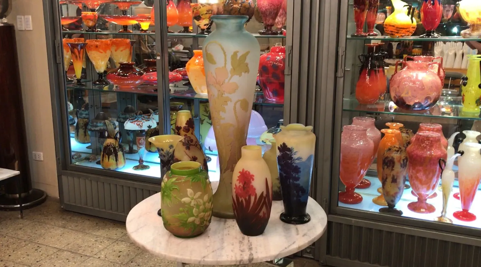 antique signed glass gallé displayed among colorful antiques