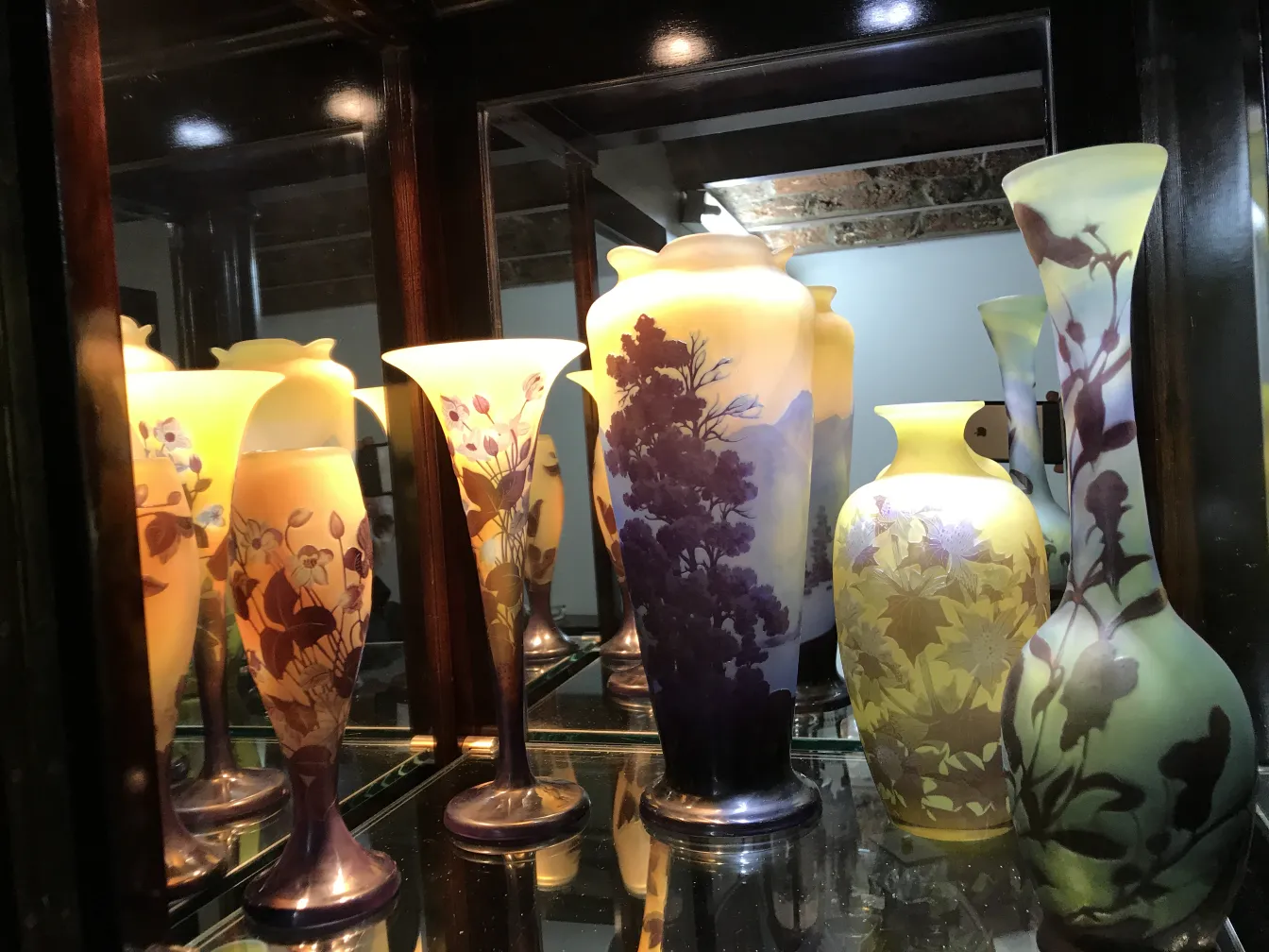 Vasi antichi in vetro firmato Gallé, colori tenui e dettagli floreali.