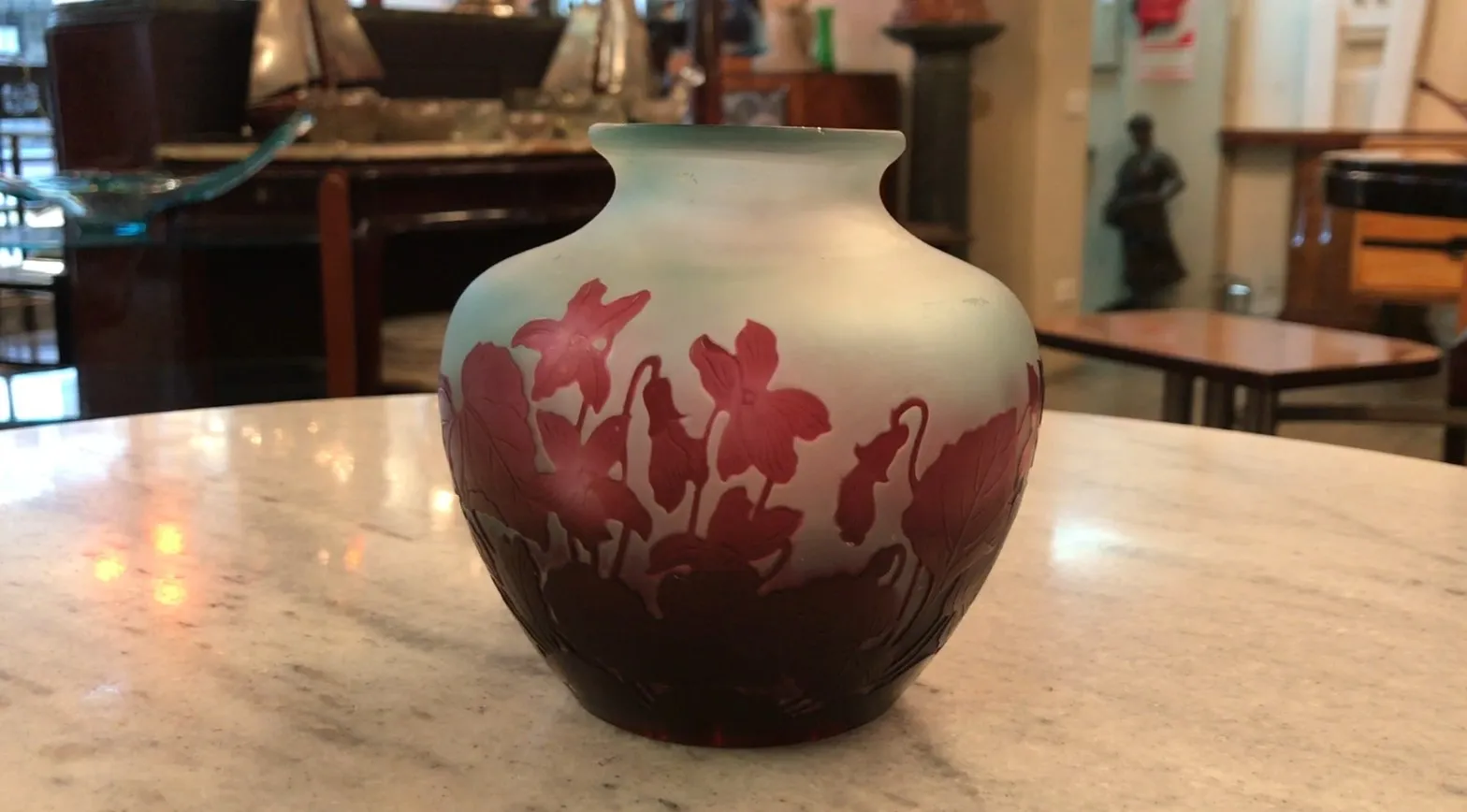 jarrón antiguo de vidrio firmado Gallé con diseño floral, en una mesa