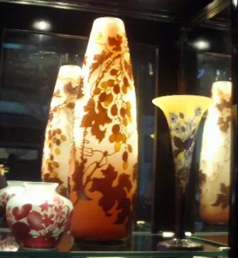 Antiquariato: vetro firmato Galle illuminato, decorazioni in colori caldi.