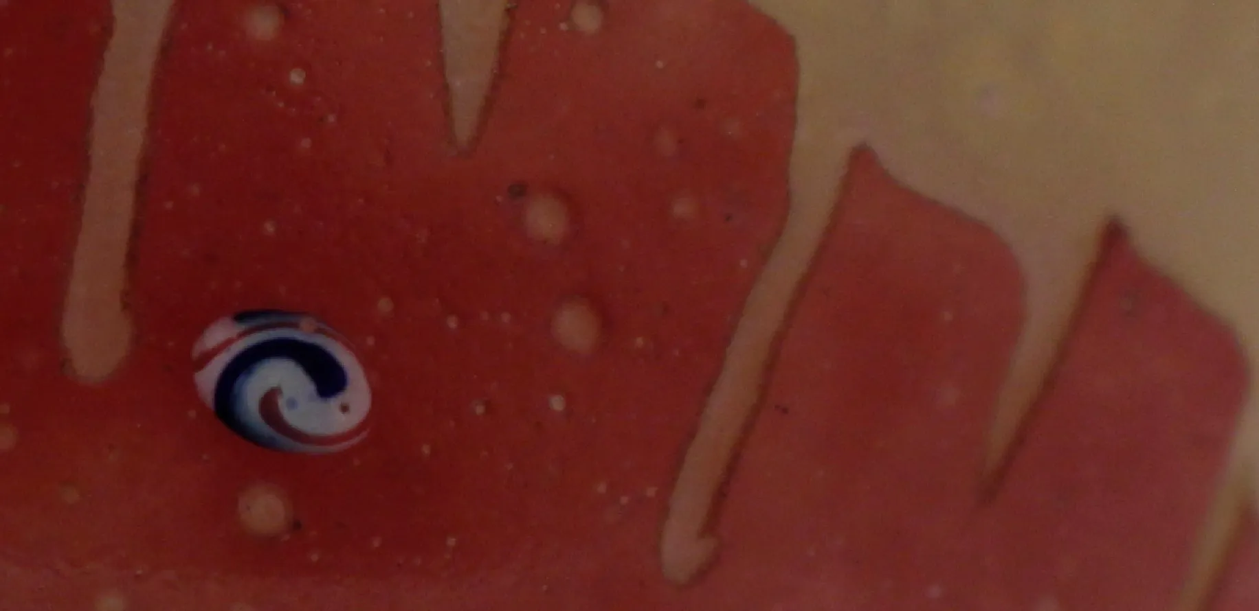 Verre signé antique avec des détails colorés ressemblant à des bonbons.