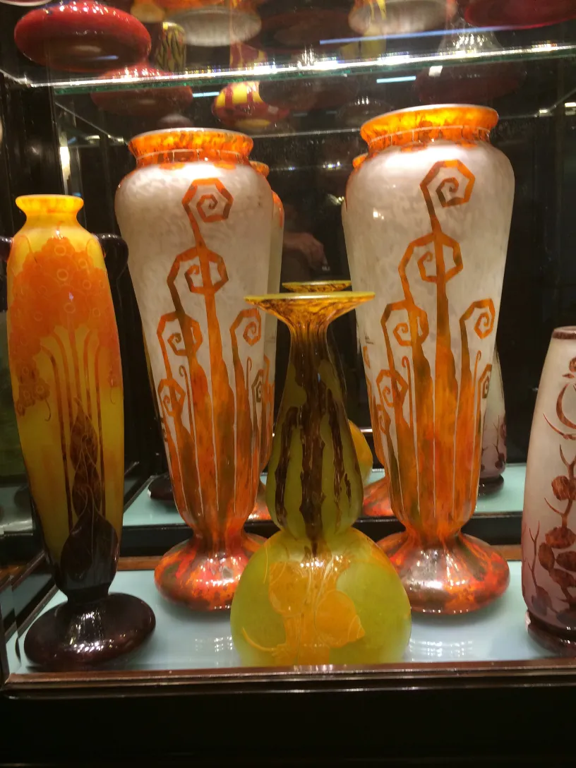 Vasos de vidro antigos assinados com cores vibrantes e formas decorativas na vitrine