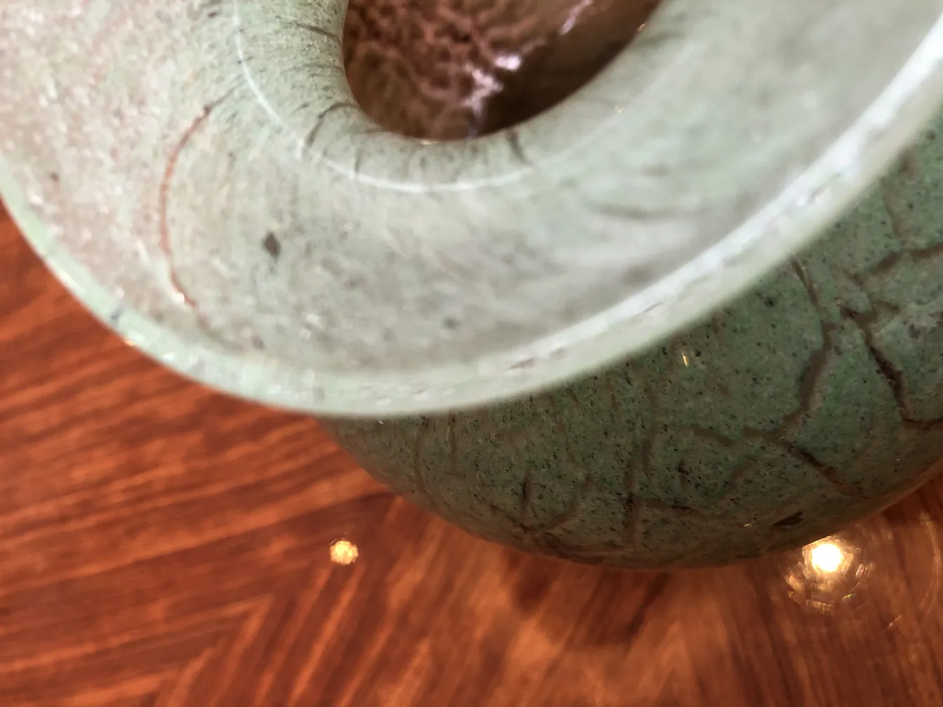 Detalhe de vidro assinado antigo com design distinto em fundo de madeira.