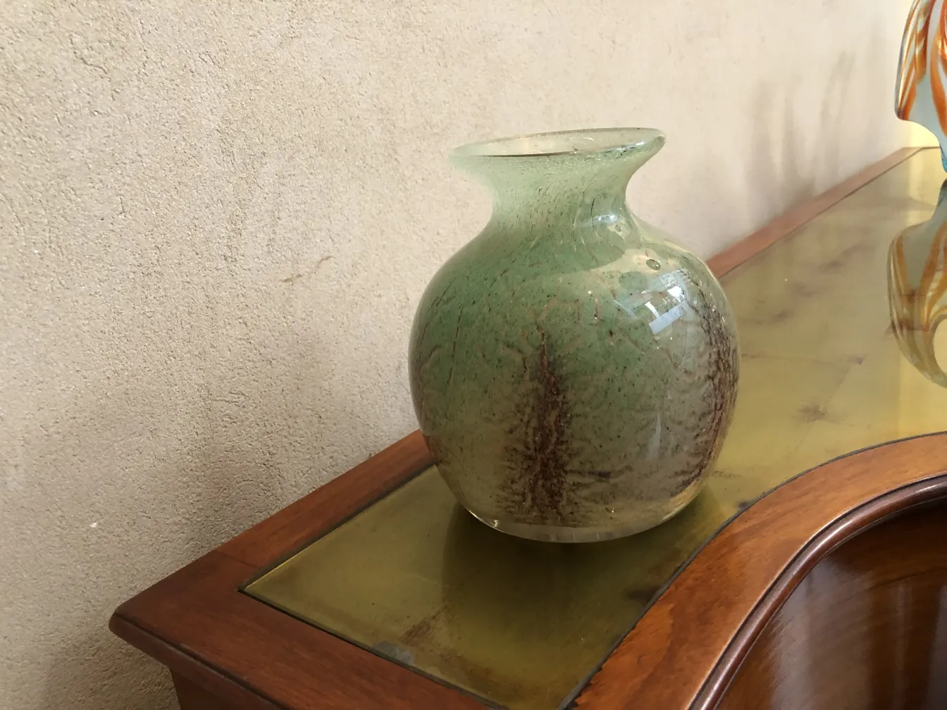 vase in vetro firmato verde con dettagli sottili su un tavolo di legno