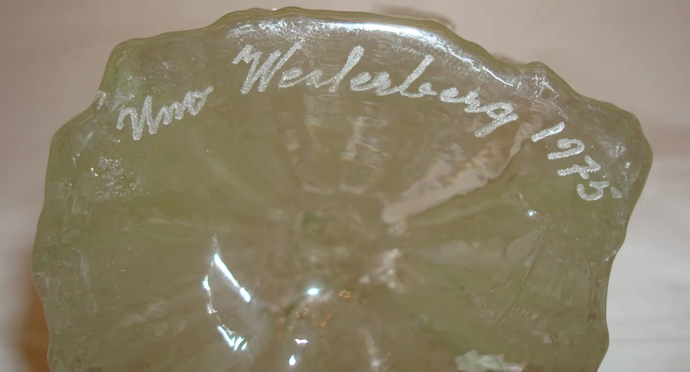 Vidrio firmado con inscripciones decorativas, vintage, en un ambiente antiguo.