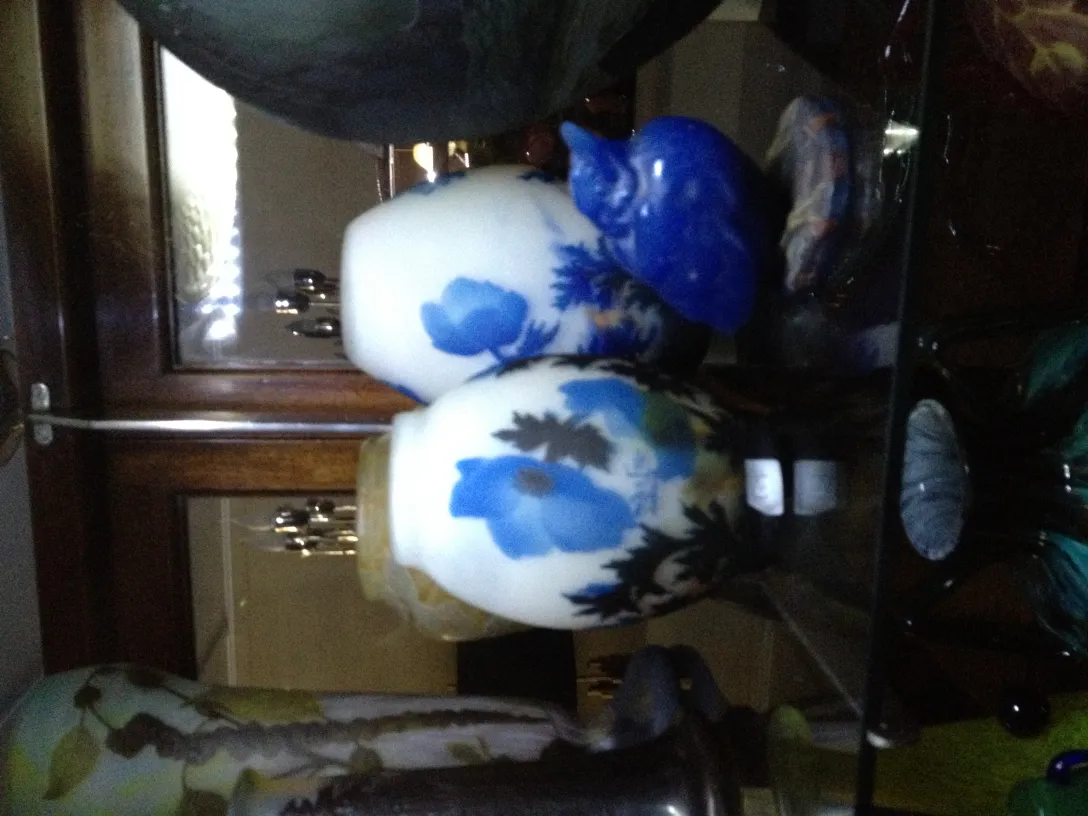 Signiertes Glas mit Blumen auf einem antiken Regal