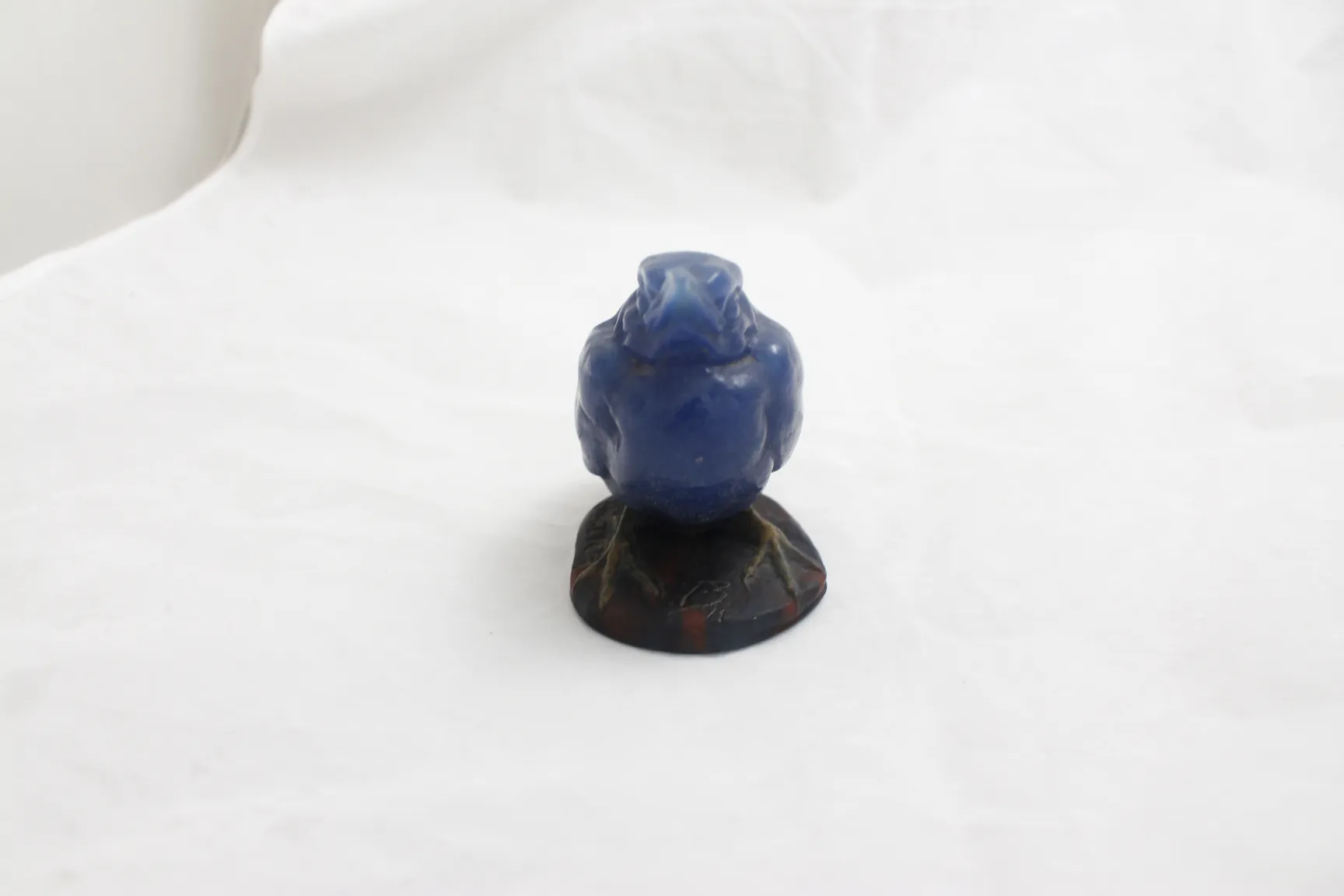 Antike Figur aus signiertem Glas, blaue Farbe auf dunklem Sockel.