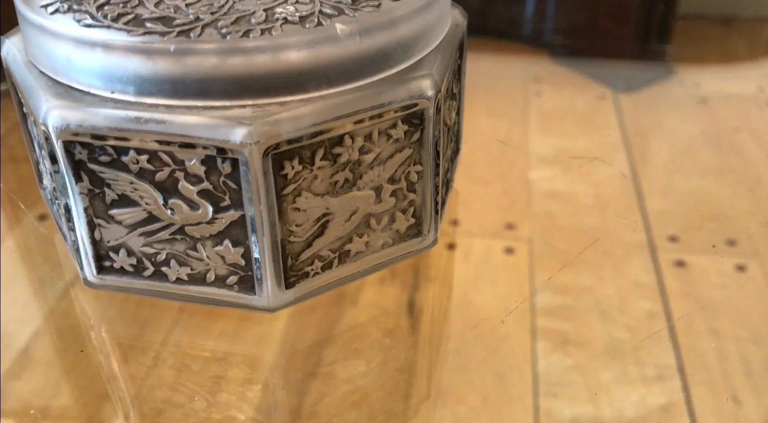 Antikes signiertes Glas mit kunstvollen Verzierungen in einem eleganten Umfeld.