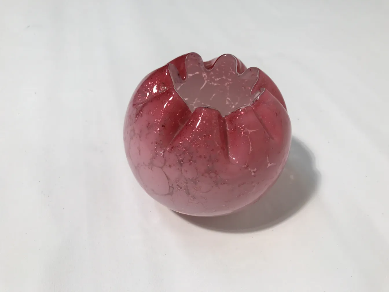 Vaso in vetro firmato rosa con bordi ondulati e dettagli decorativi.