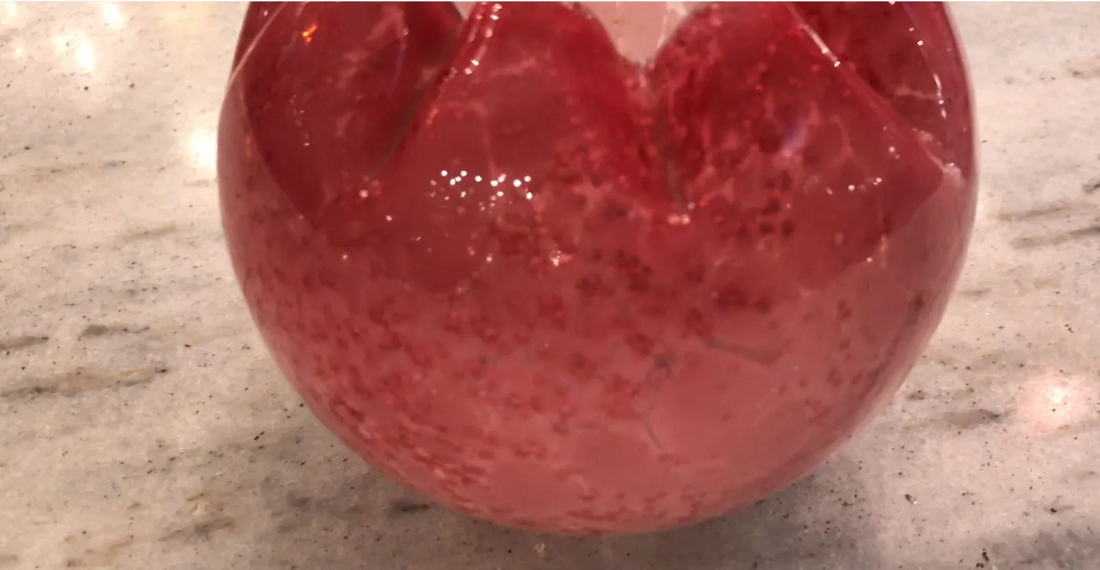 Vetro firmato antico di colore rosso con dettagli brillanti.