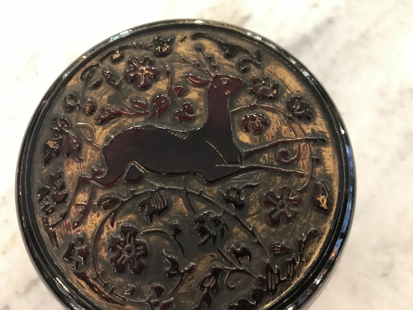 Altes Glas mit erhabenem Design eines Rehs und Blumen