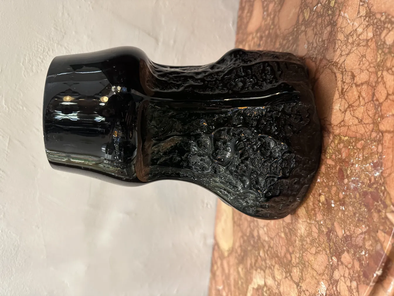 Verre signé de forme élégante, avec une texture unique sur un fond en marbre.