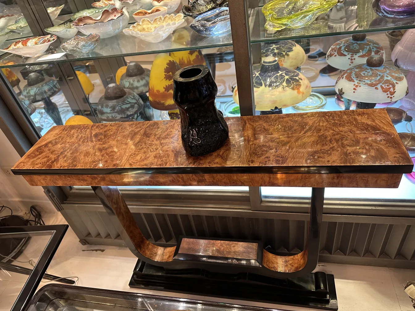 Vidrio firmado antiguo con tono cálido exhibido en un entorno elegante.