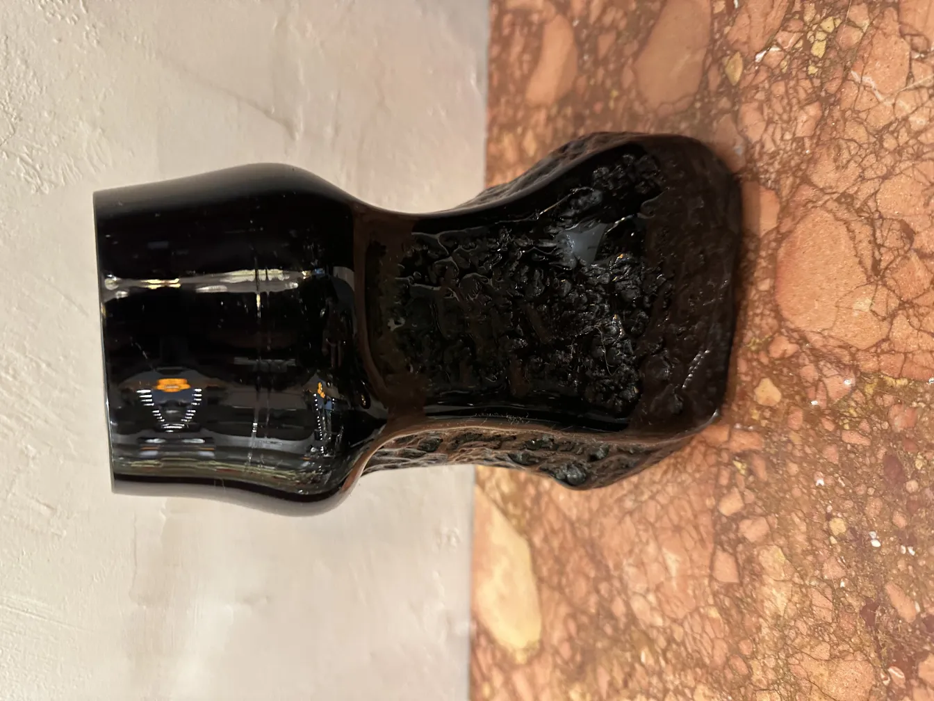 Vase en verre noir avec une signature ancienne, décoration en relief.