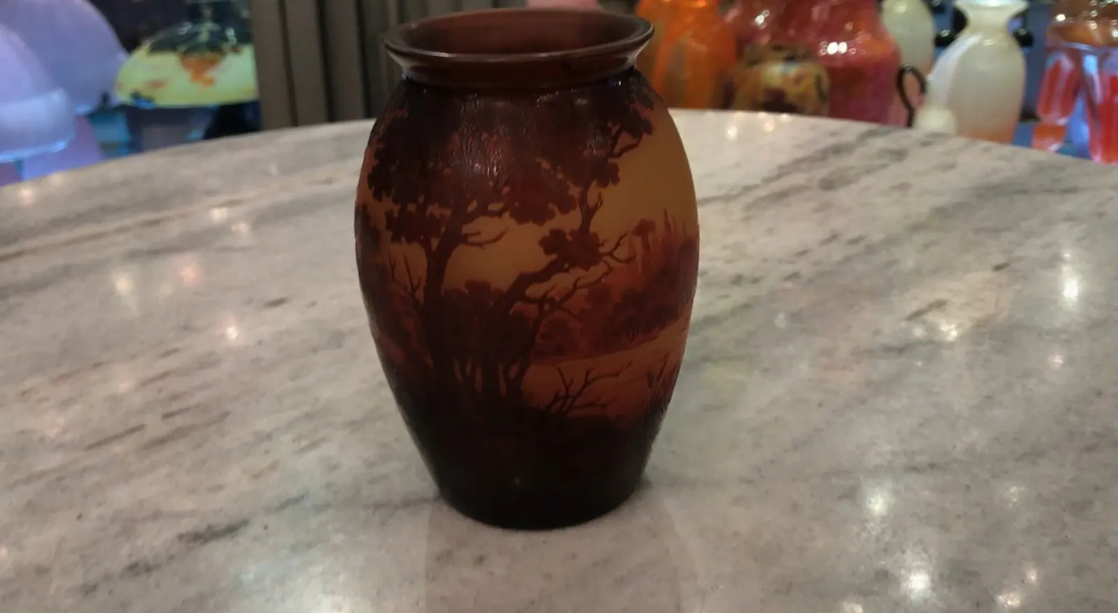 Verre signé D'Argental présentant des paysages naturels aux teintes chaleureuses.