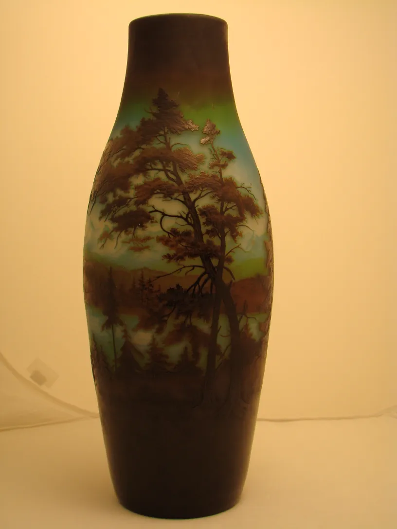 Antike Vase mit beleuchtetem Landschaftsmotiv in Braun- und Blautönen.