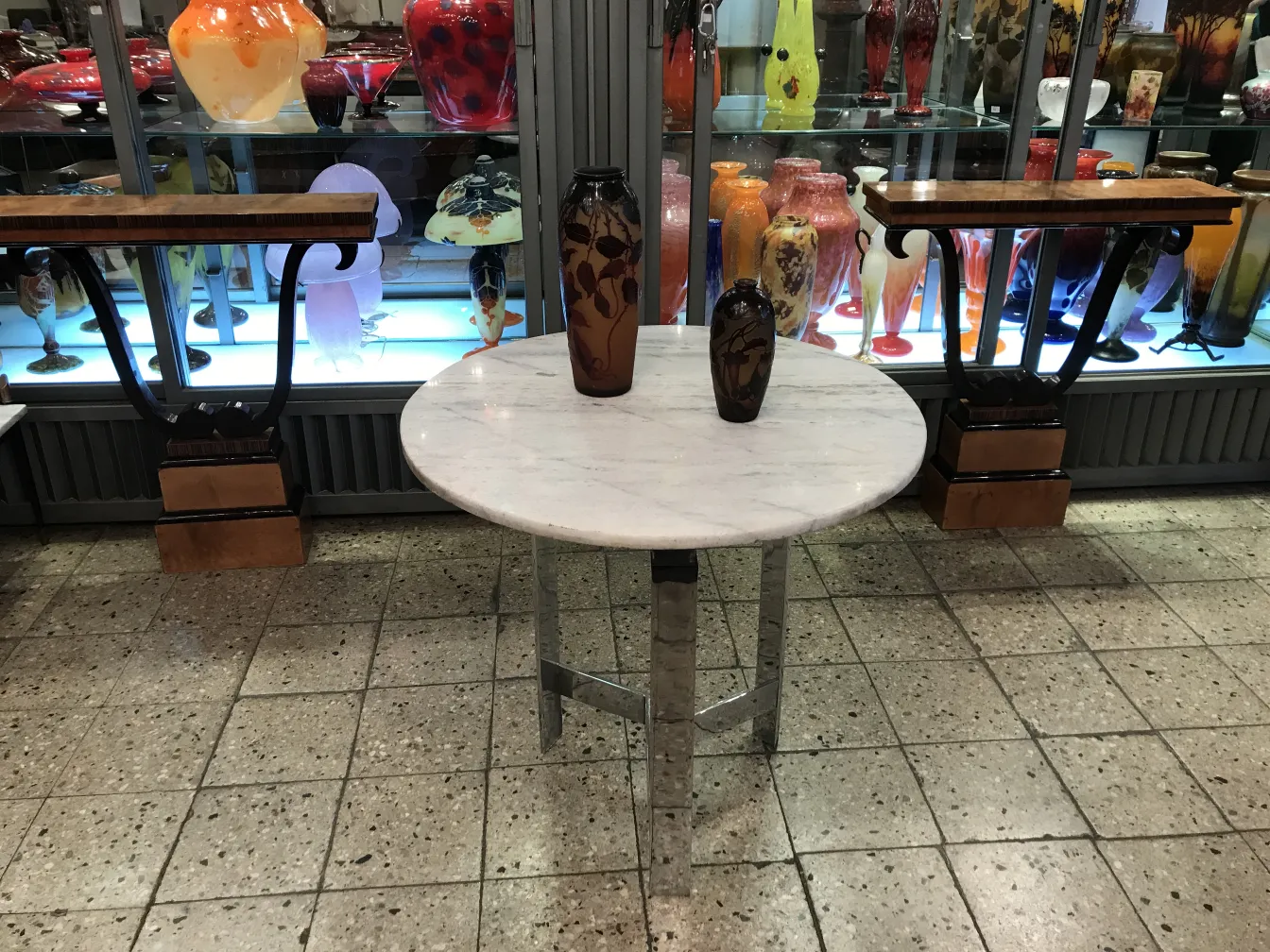 Vidrio firmado D'Argental sobre mesa con decoración variada al fondo