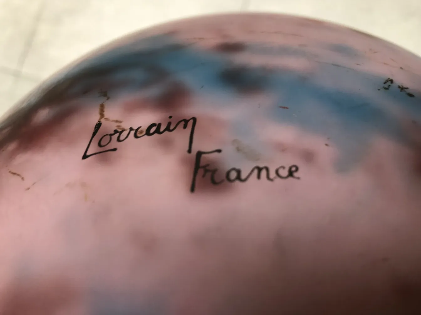 Antique glass signed by Lorrain with a soft background of colors.