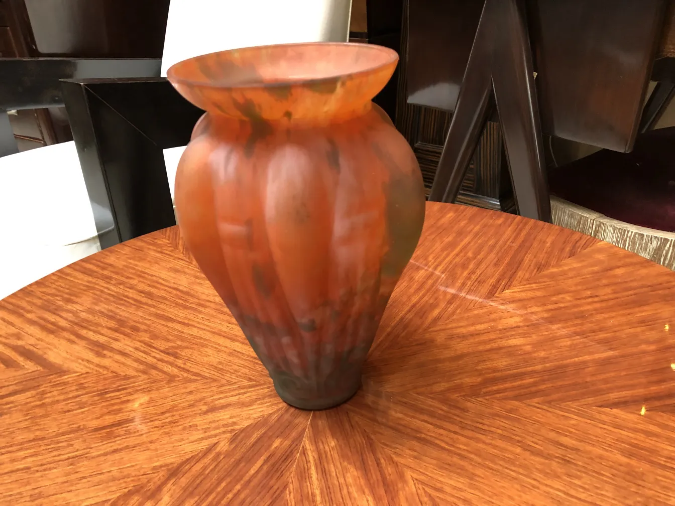 An elegant signed glass by Lorrain on a wooden table.