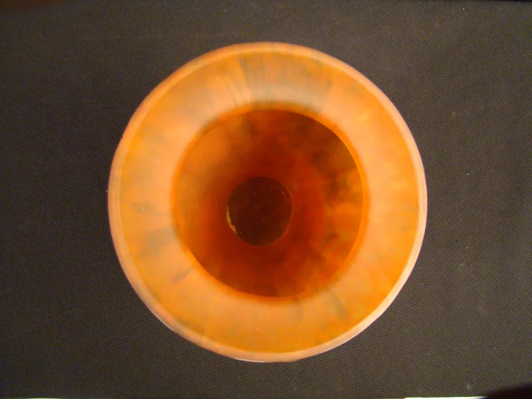 Top view of an antique signed glass Lorrain with orange hues.
