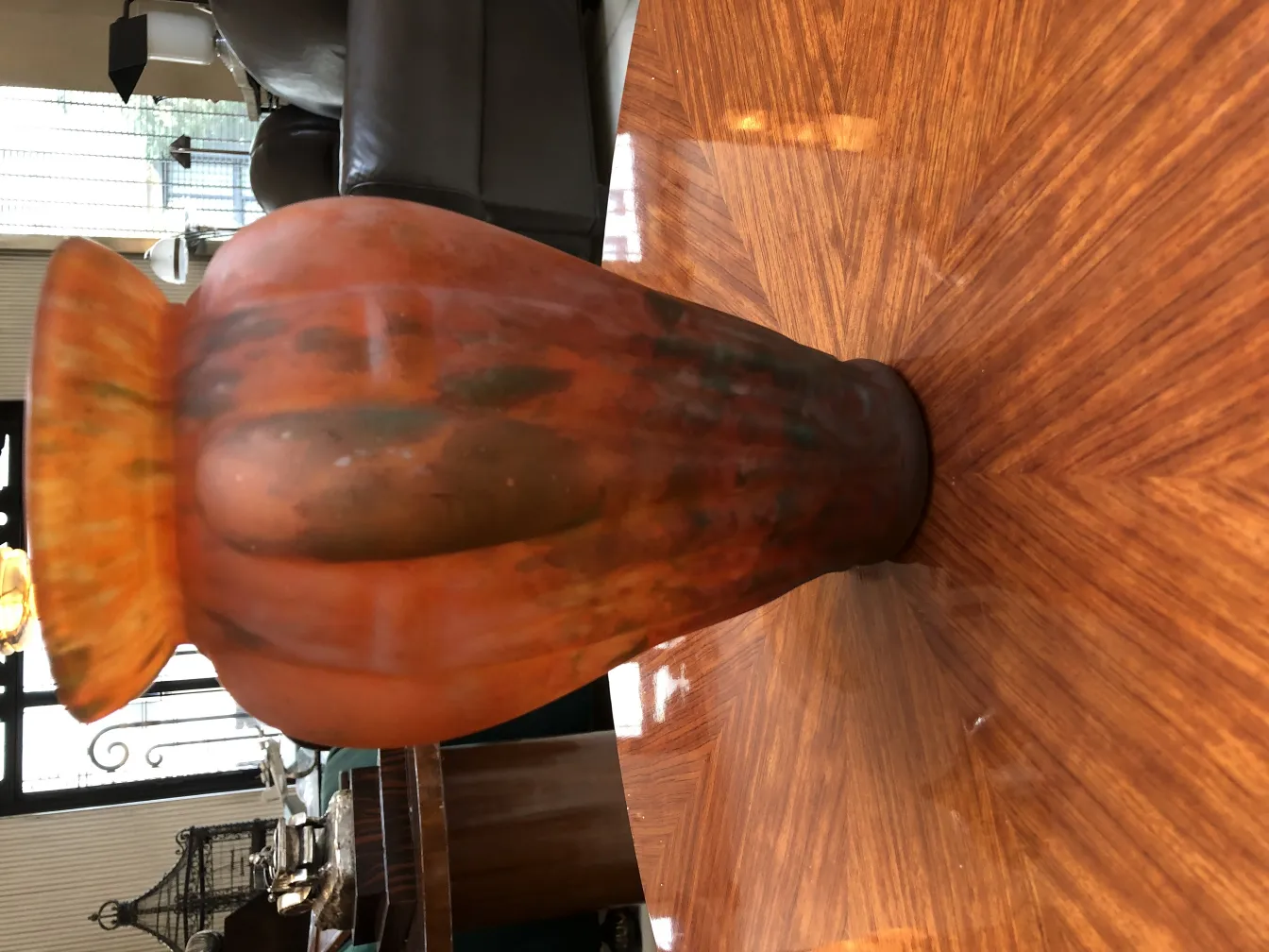 Vase of signed glass by Lorrain, orange color with distinctive design, situated on wooden table
