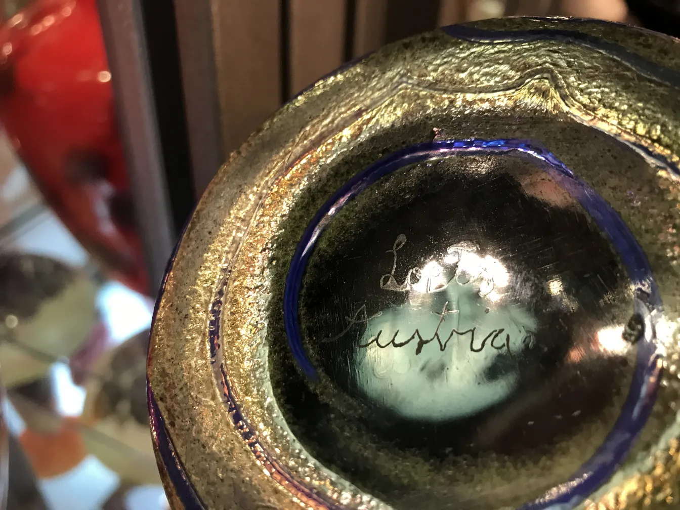 Dettaglio di vetro antico firmato da Loetz, lucido e decorativo.