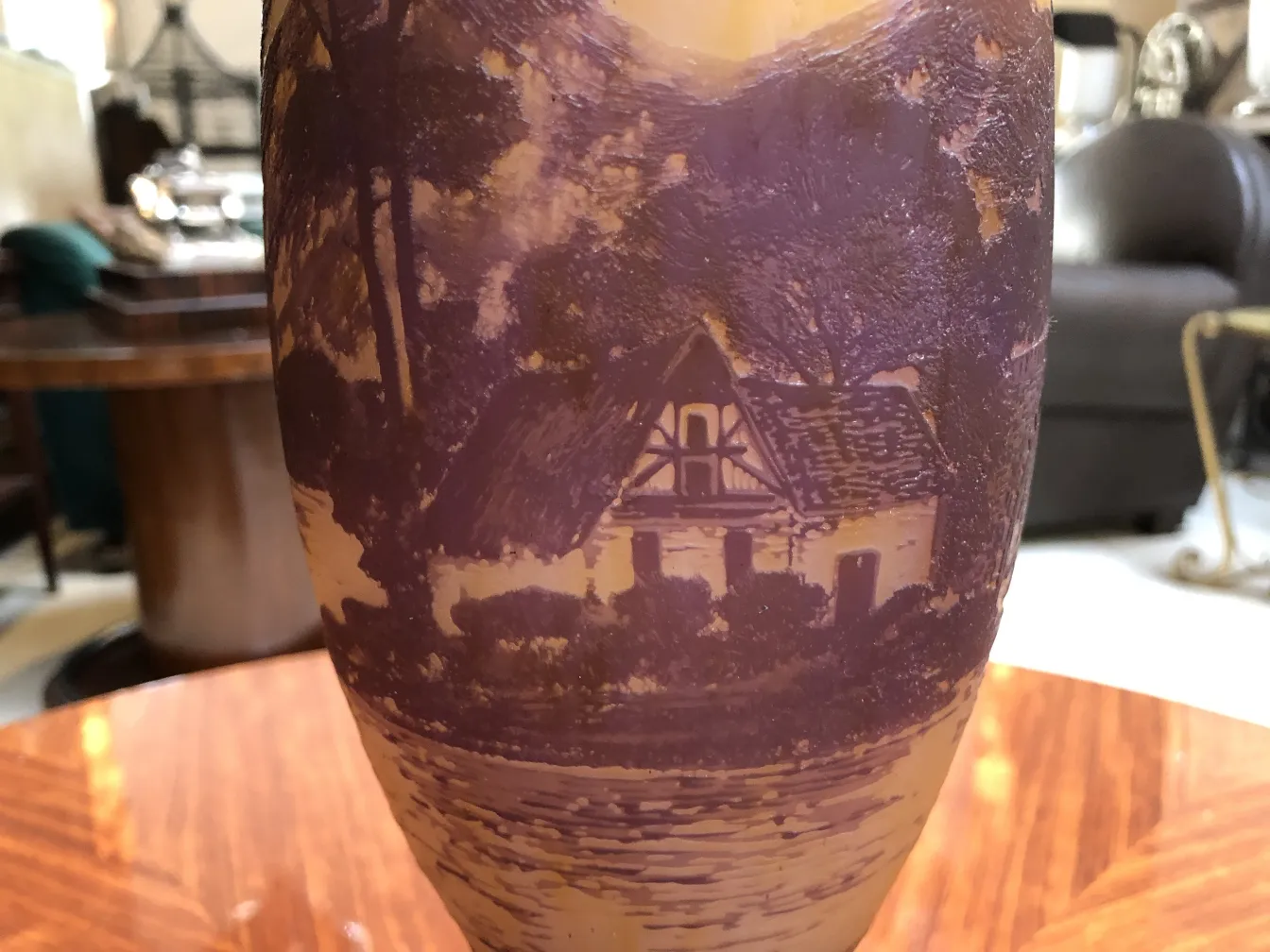 Detail of antique signed glass, featuring landscape and house. Light background.