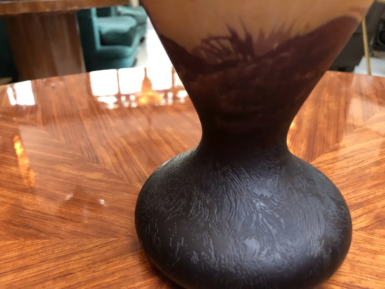 signiertes Glas mit dunklem Design auf einem Holztisch