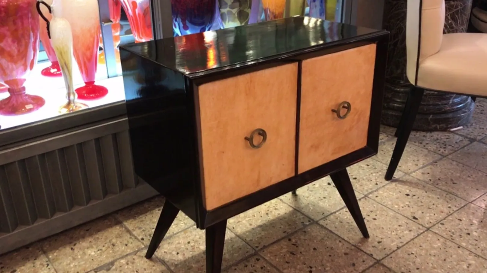 antique bedside table with a shiny finish and light wood doors, set in an elegant ambiance