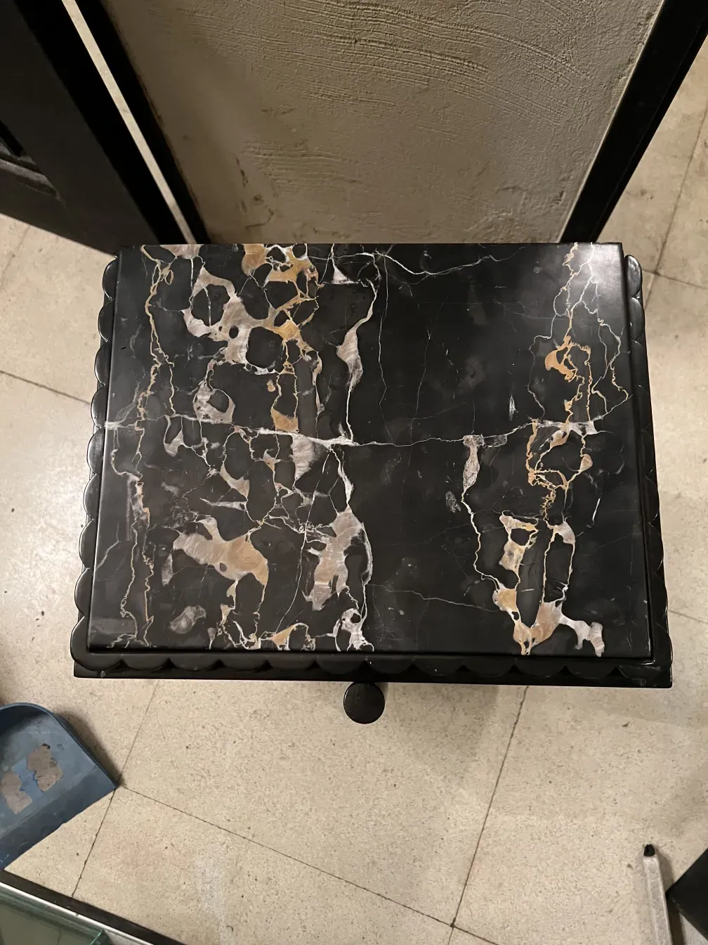 Comodino antico con superficie decorativa e dettagli unici, in un ambiente classico e accogliente.