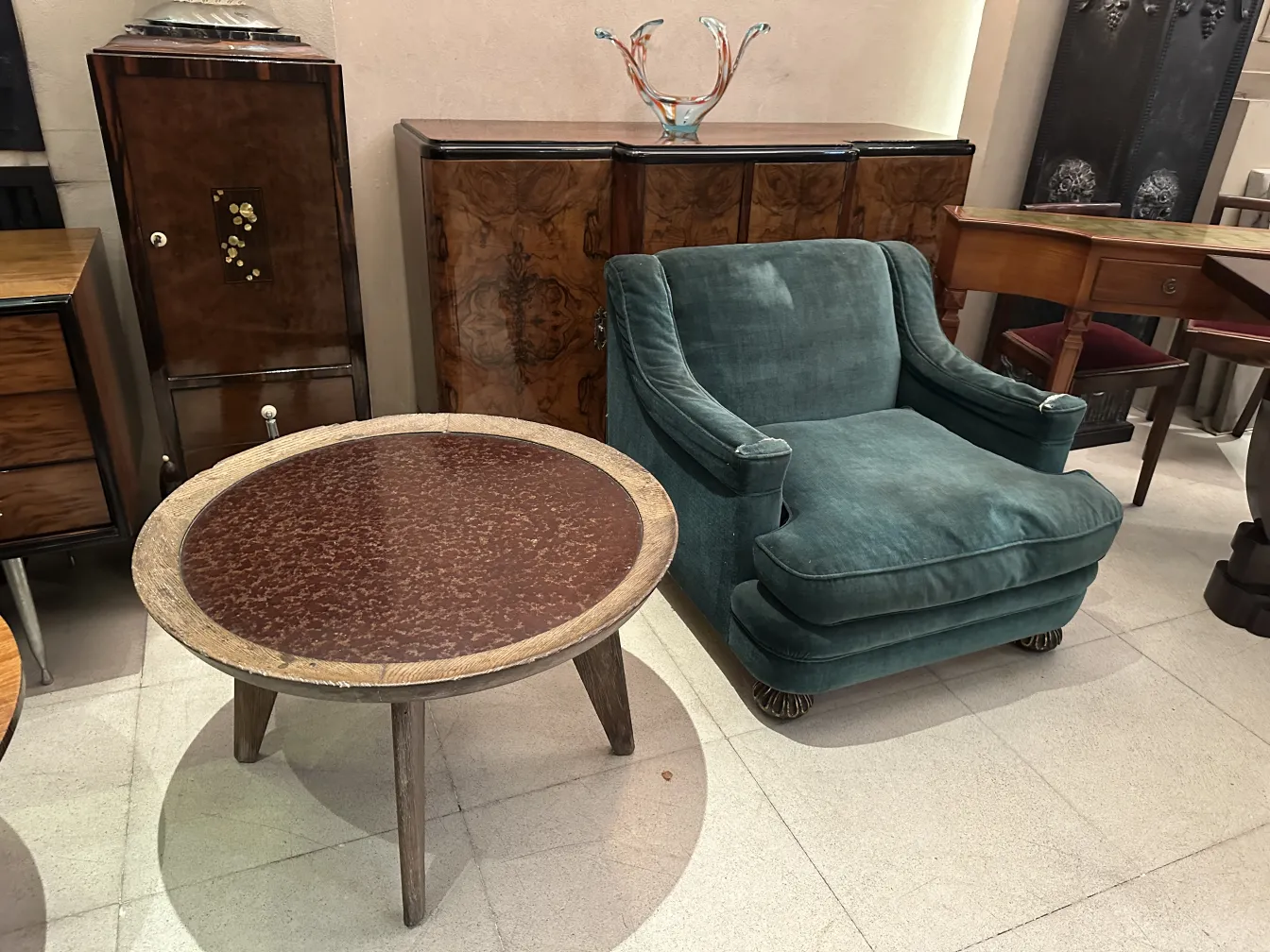 tavolino da caffè antico elegante accanto a una poltrona verde