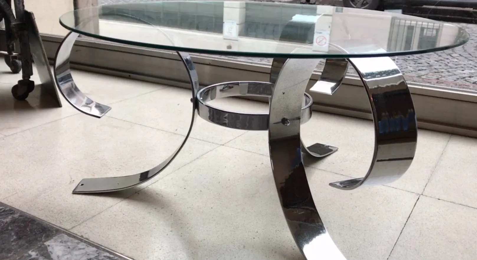 couchtisch mit gebogener metallbasis und glastischplatte