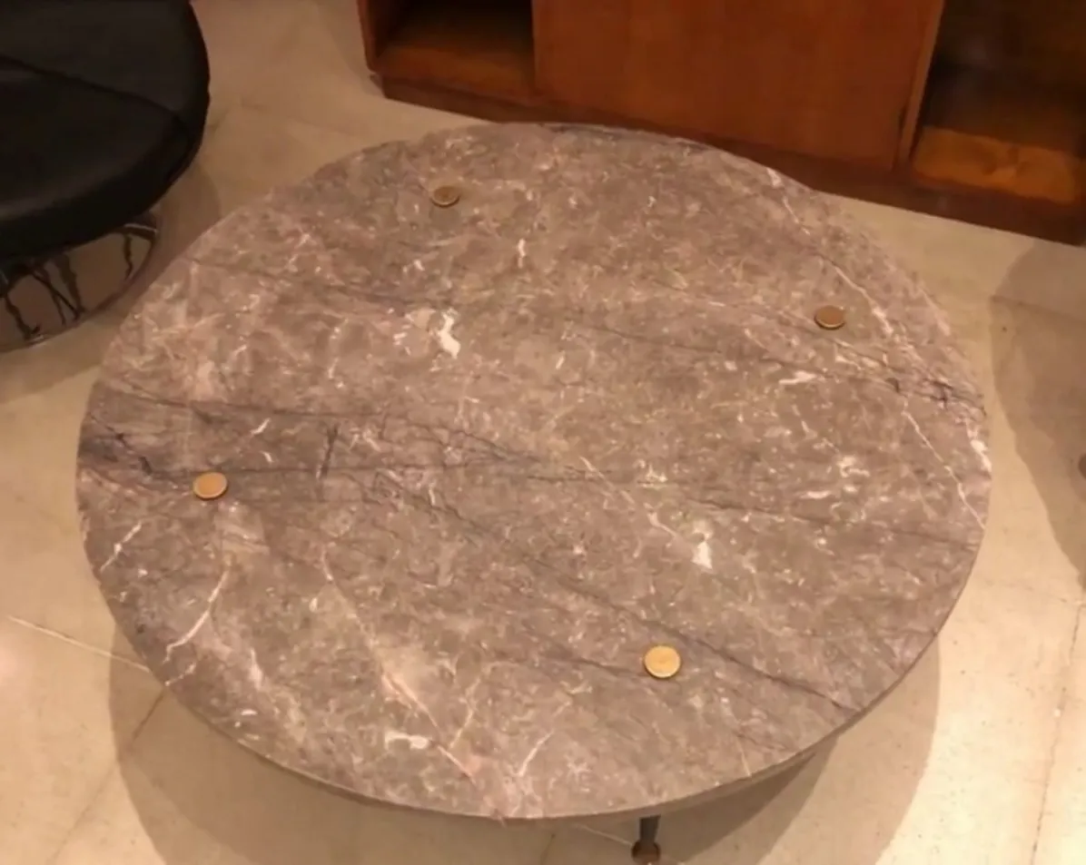 tavolino da caffè antico rotondo con superficie decorativa e gambe in metallo, in un ambiente accogliente