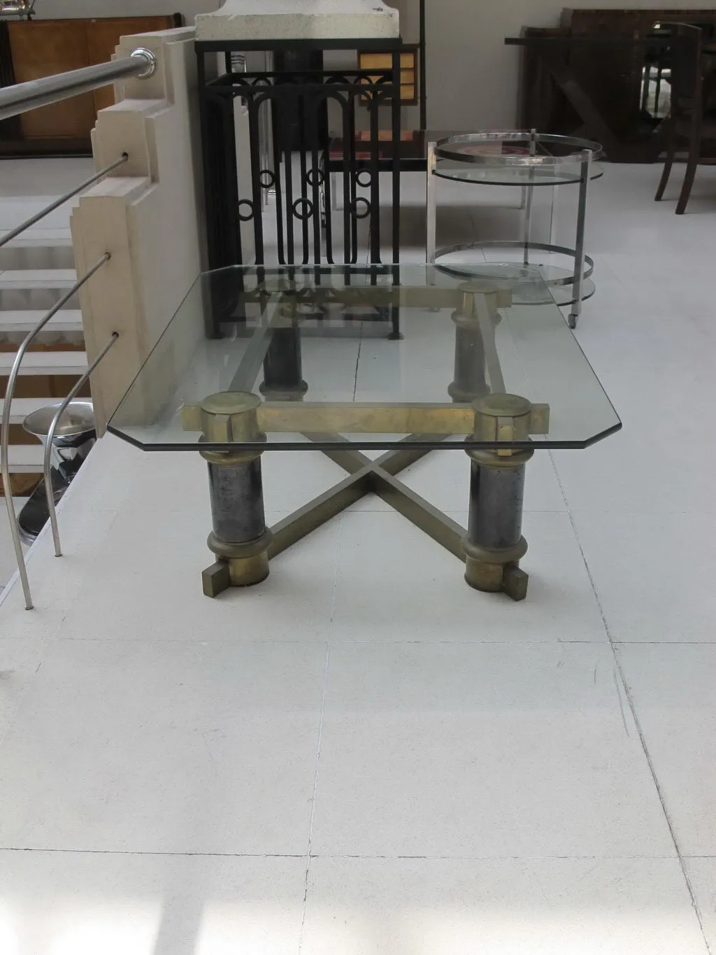 table basse antique en verre avec base décorative, cadre minimaliste
