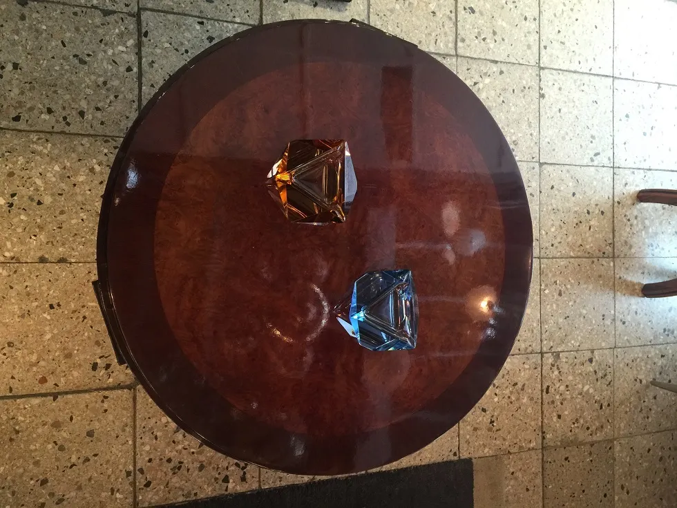 Mesa de centro antiga com decorações vibrantes e objetos ao redor.