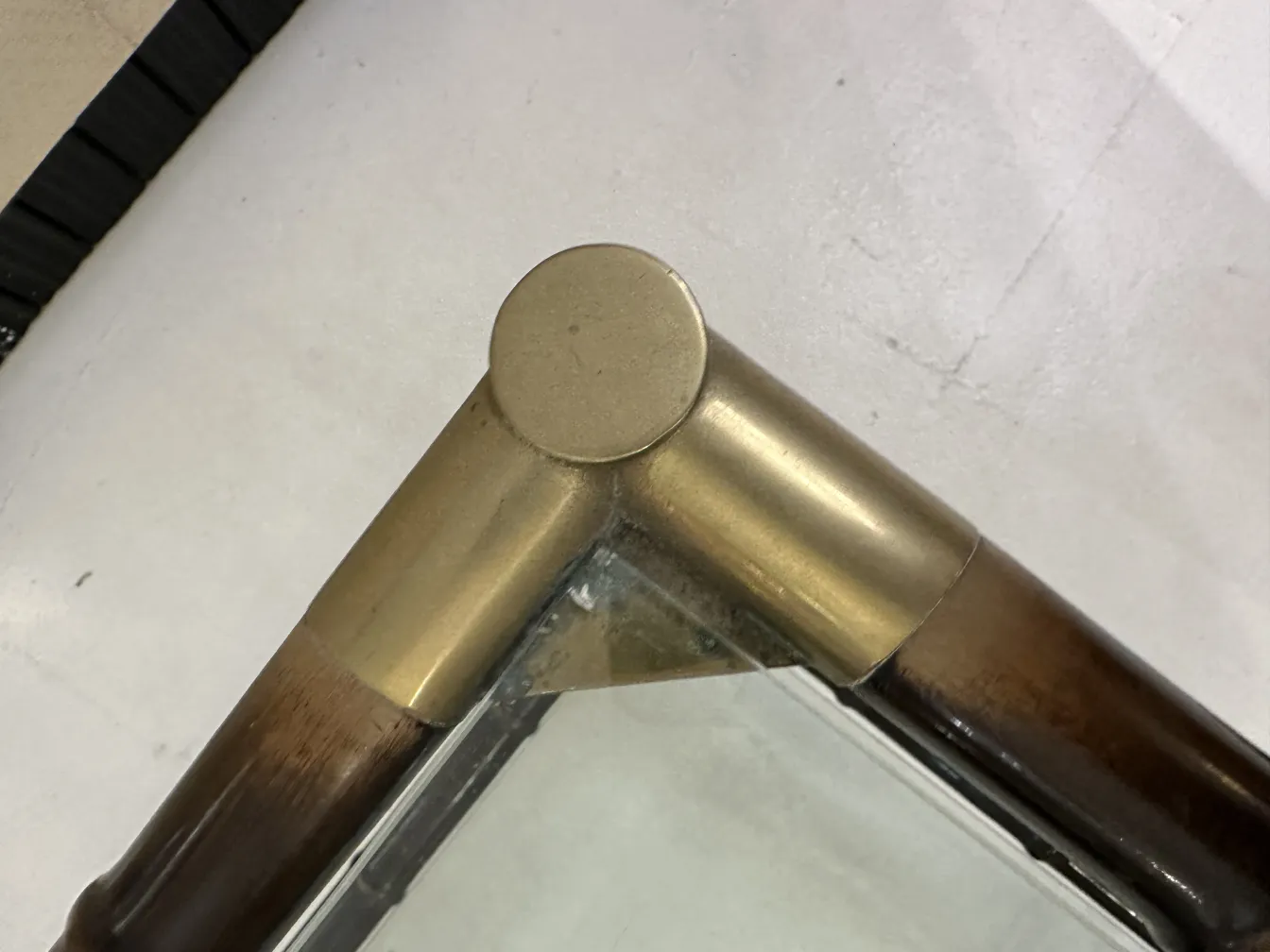 vista superior de una mesa ratona antigua con esquinas redondeadas y detalles en bronce, ambientada en un entorno elegante.