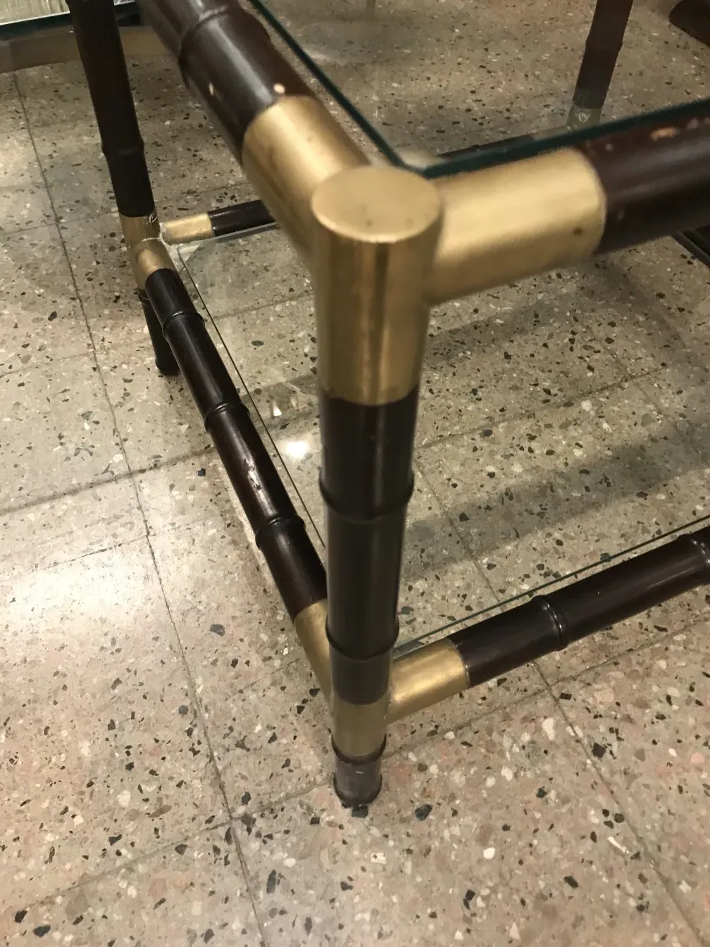 Vista de uma mesa de centro antiga com detalhes em dourado, estilo william billy haines