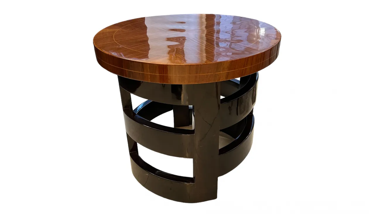 Petite table ancienne ronde avec un socle noir et une surface brillante.