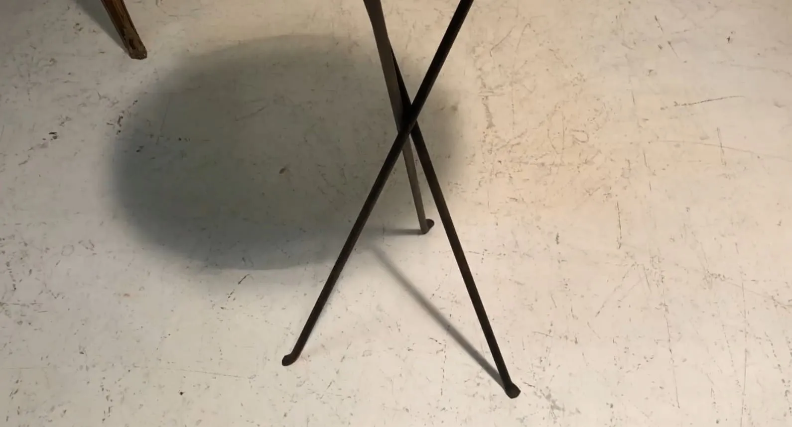 antique small table with crossed legs in neutral setting