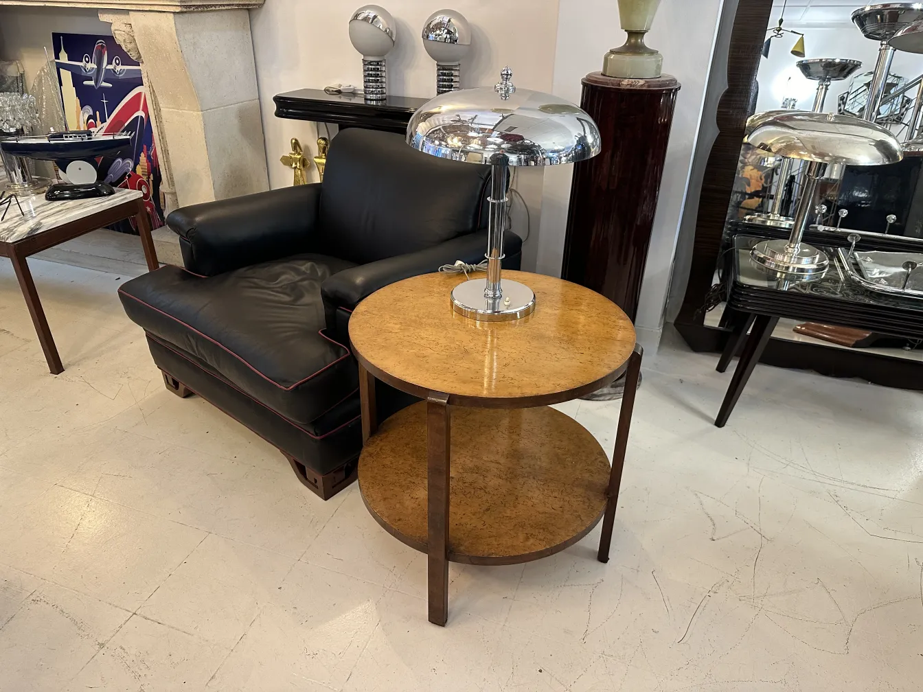 antiker kleiner runder Tisch mit Regal in klassischem Setting mit schwarzem Sofa