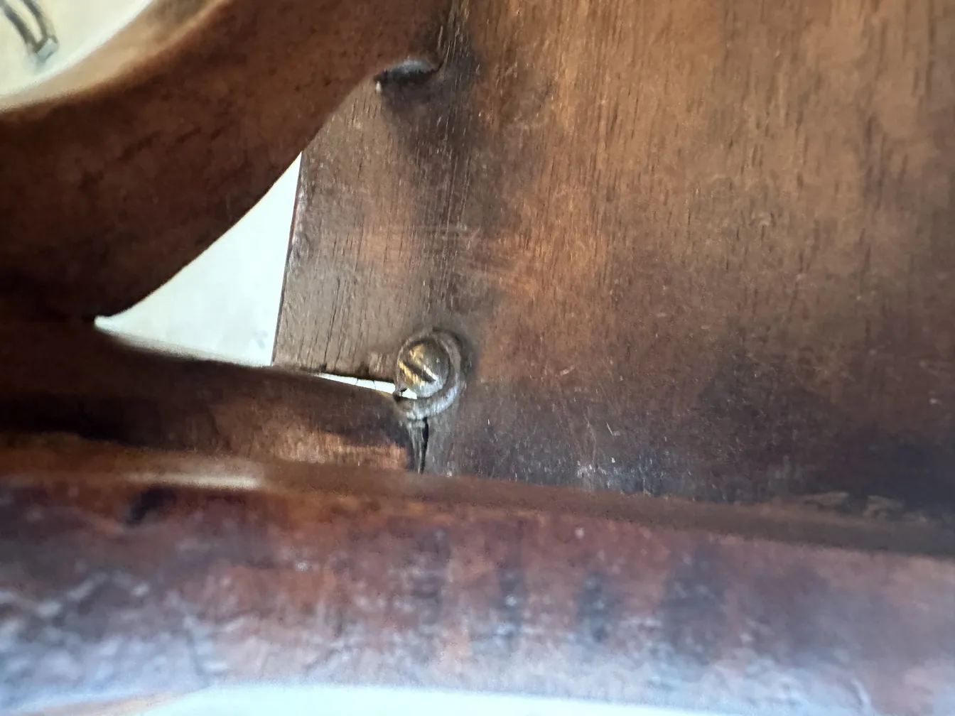 Mesinha antiga com detalhes na parte de trás da estrutura.