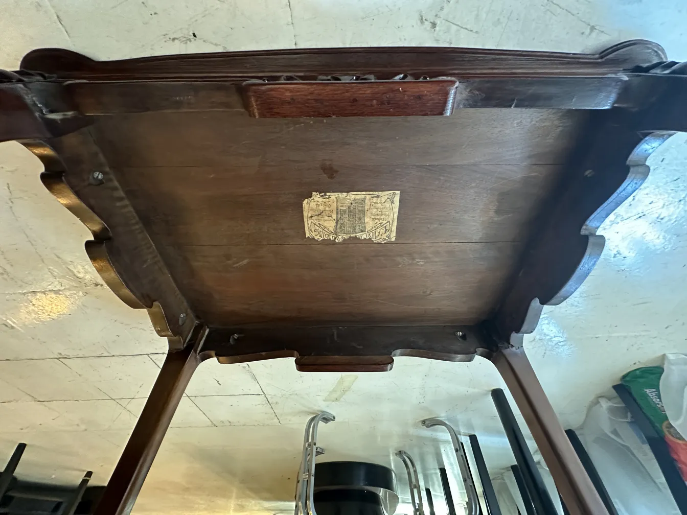small antique table with decorative details and visible label