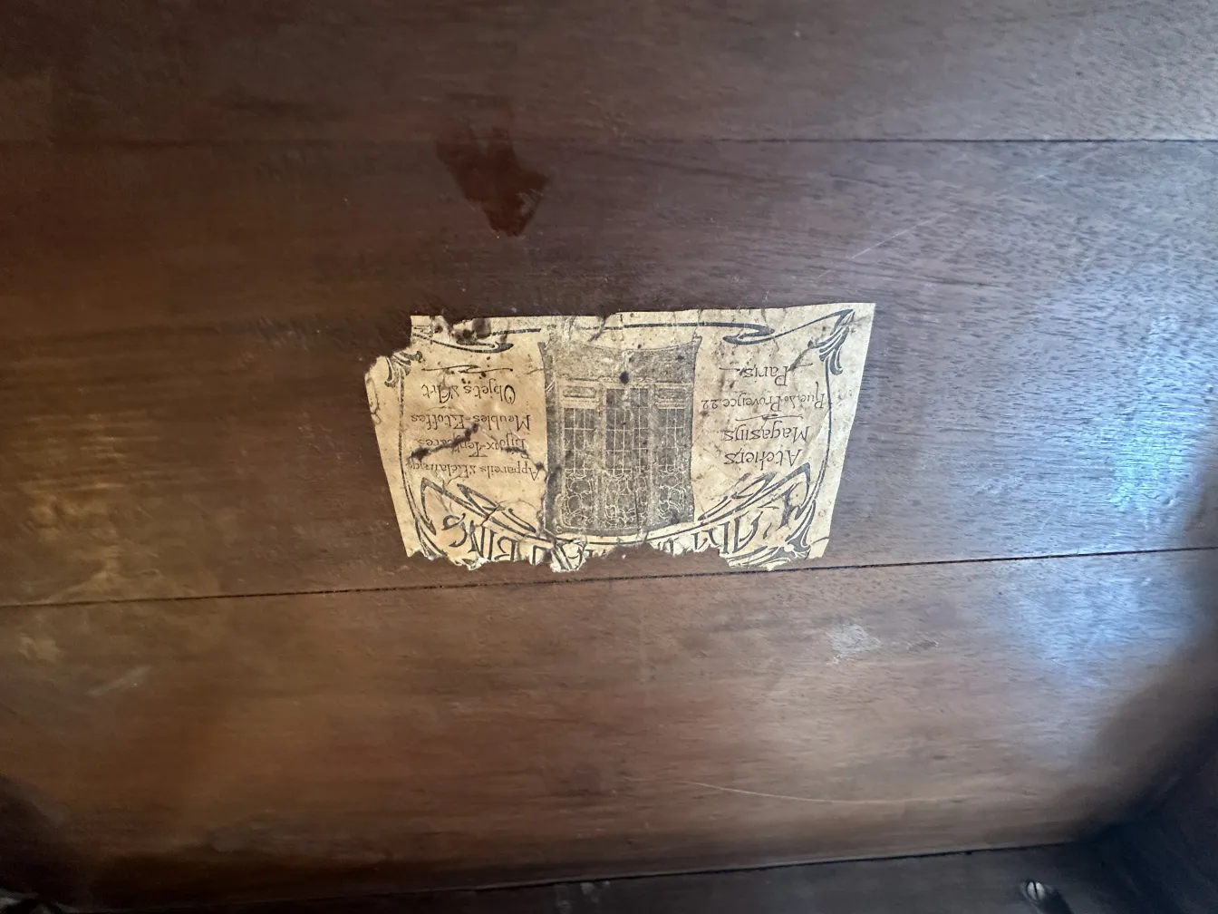 Mesinha antiga com etiqueta da Maison L'art Nouveau, em um ambiente acolhedor.