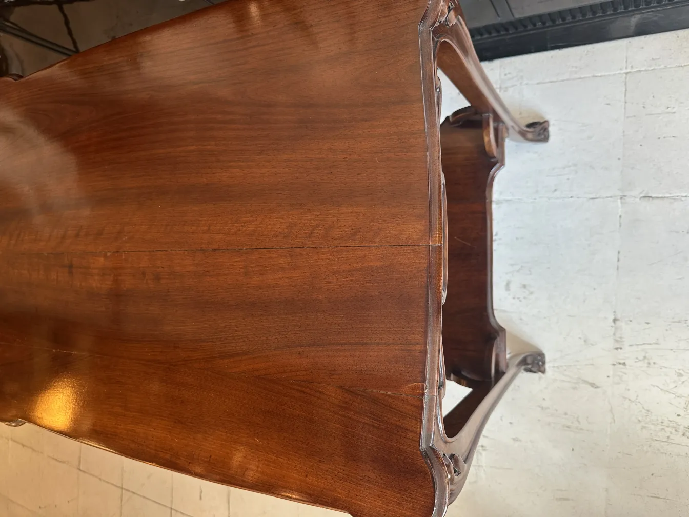 Antique small table with detailed legs, cozy house ambiance.