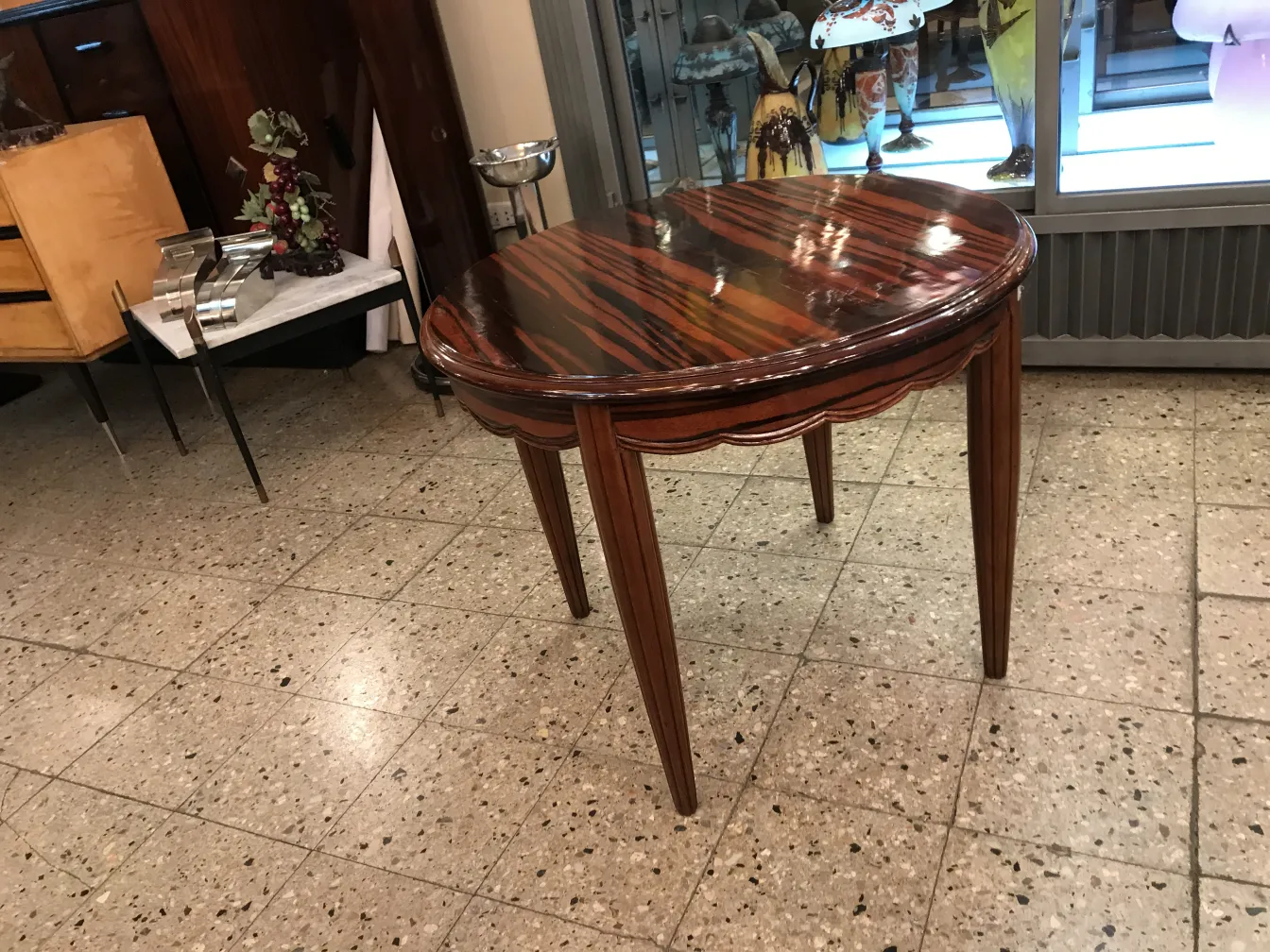 Petite table ancienne de forme ronde avec une finition brillante dans un cadre décoratif
