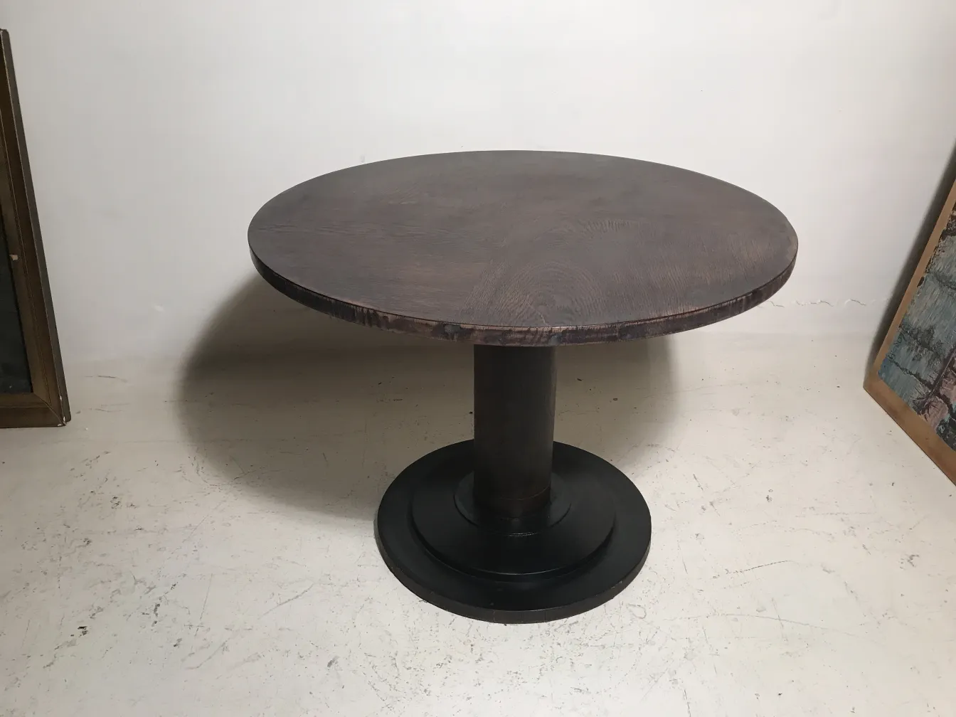 antique round small table with black base and light background