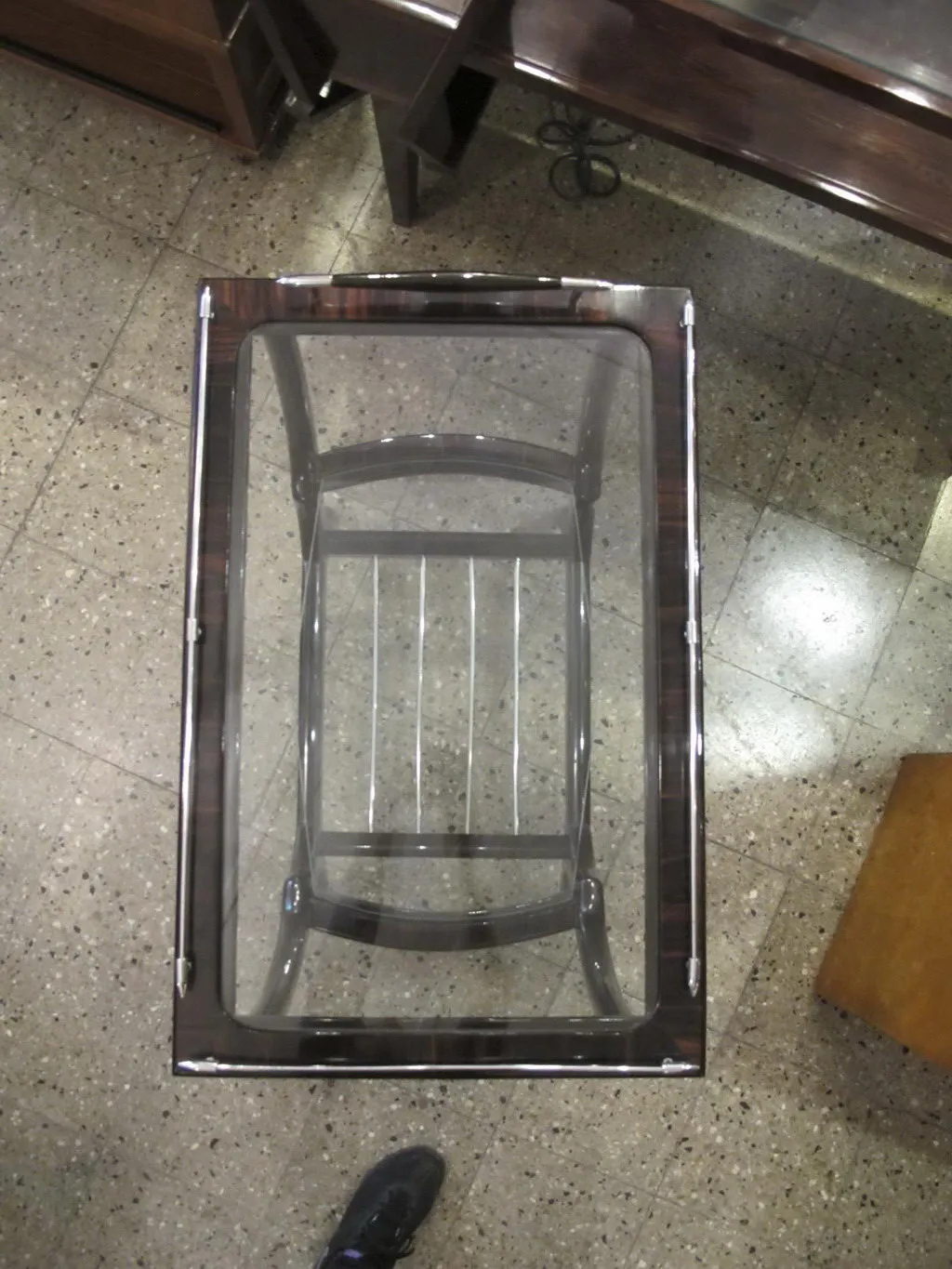 Antique small table with a clover shape, in a cozy setting with dark furniture and mosaic floor